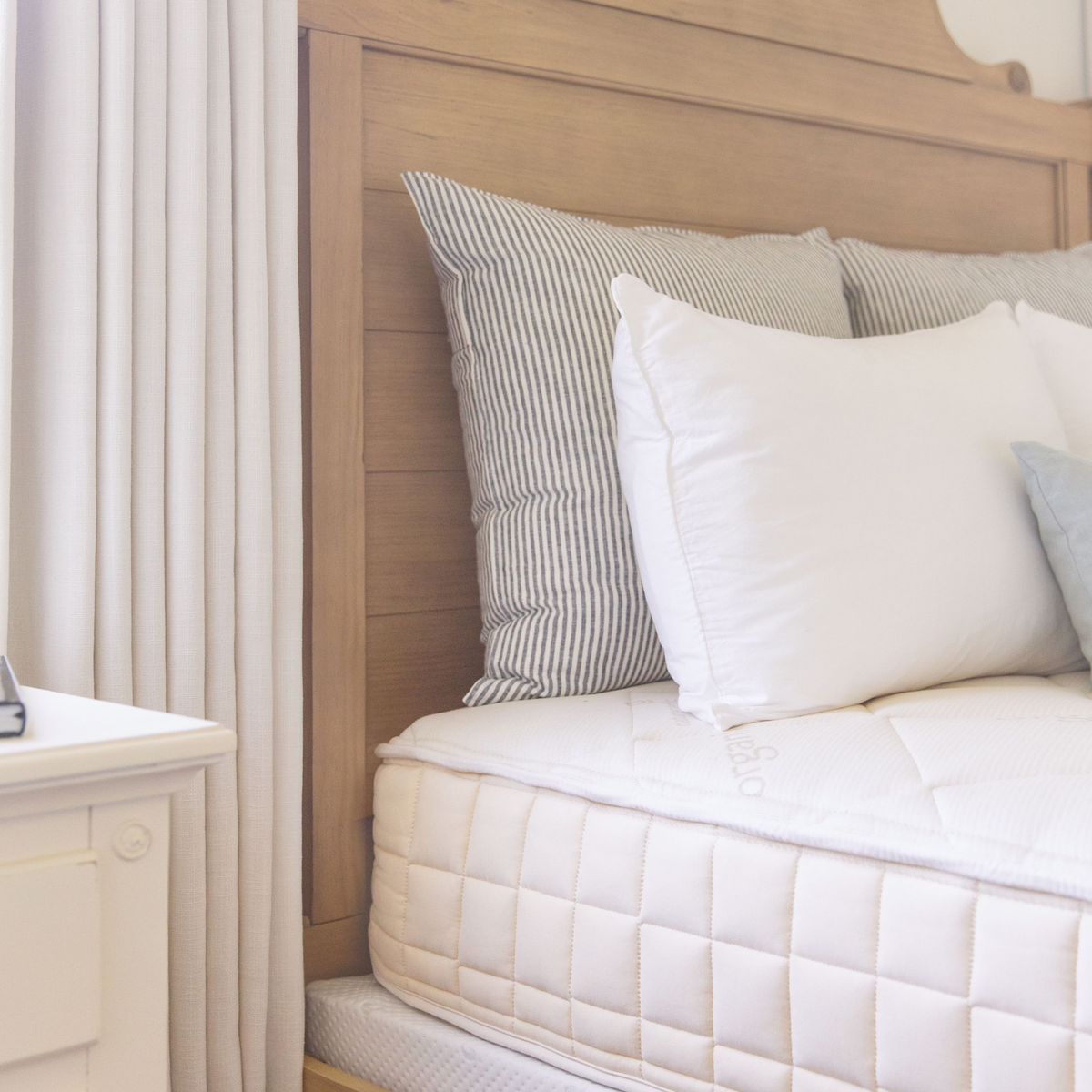 Side view of the Naturepedic Chorus Latex-Free Organic Mattress with pillows