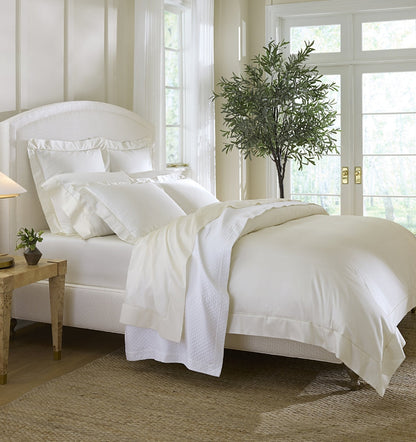 SFERRA bedding on a made bed in a bedroom