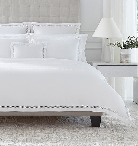 SFERRA bedding on a made bed in a bedroom