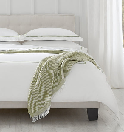 SFERRA bedding on a made bed in a bedroom