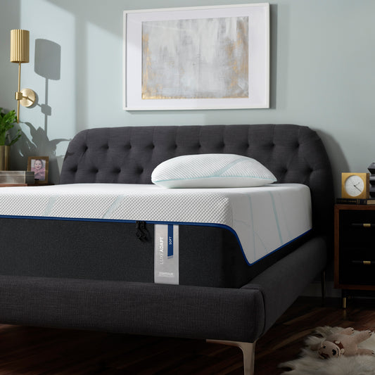 Tempur-Pedic LuxeAdapt® Soft mattress in a modern bedroom with a tufted charcoal bed frame, minimalist decor, and plush pillow, offering cloud-like comfort for side sleepers.