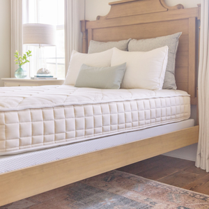 Colchão orgânico sem látex Naturepedic Chorus sobre uma cama em um quarto