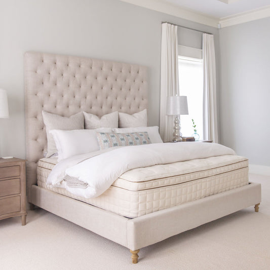 Naturepedic EOS Pillow Top Organic Mattress on an upholstered bed in a bedroom