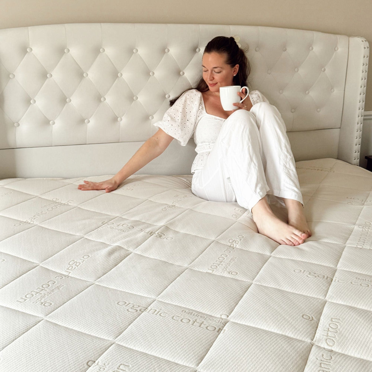 Woman sitting on a Naturepedic Serenade organic mattress