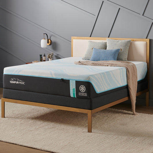 Tempur-Pedic PRObreeze® Medium Hybrid mattress in a modern bedroom with gold-accented bed frame, textured walls, and layered pillows, highlighting its breathable and supportive hybrid design.