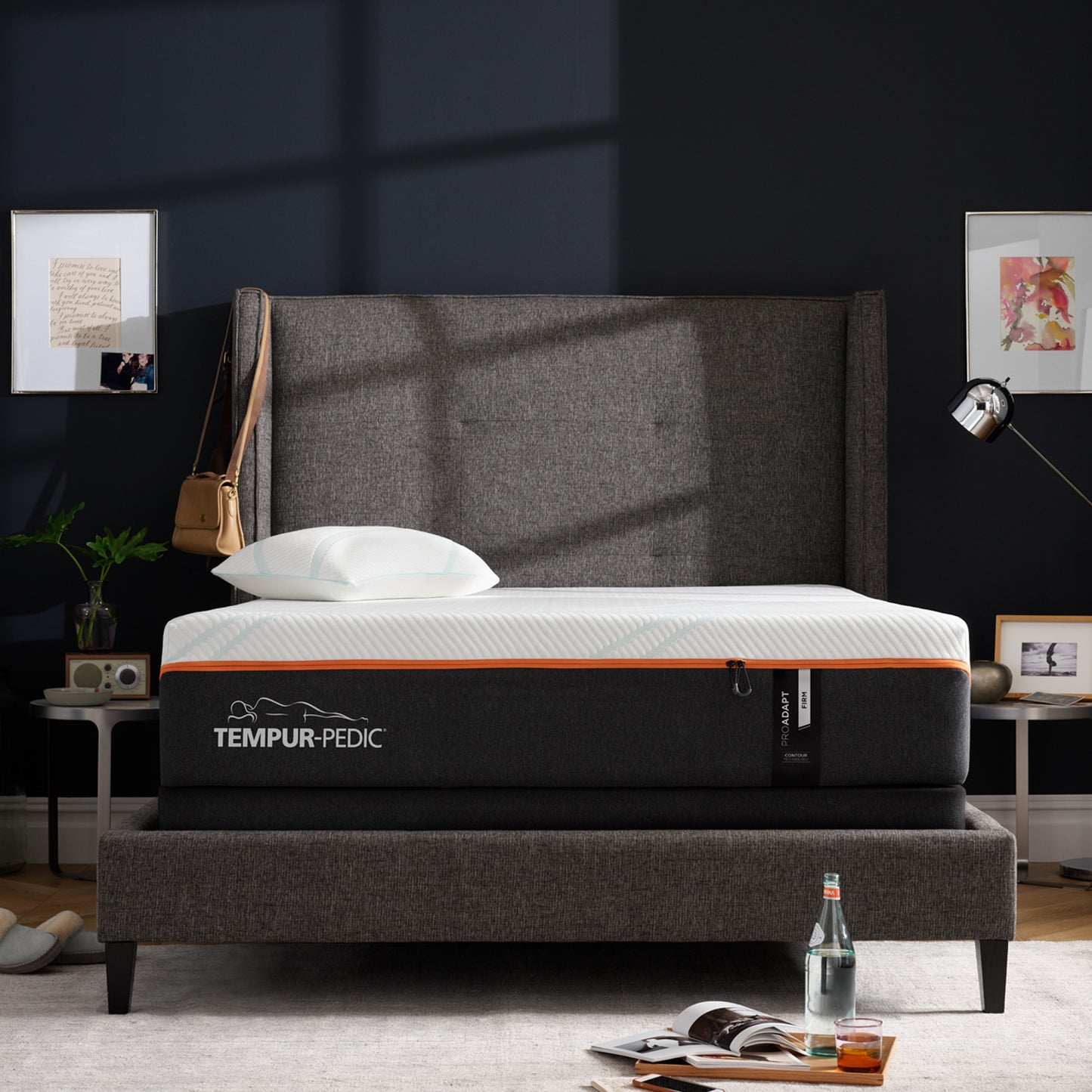 Tempur-Pedic ProAdapt Firm mattress in a stylish bedroom with dark walls and a high-back upholstered bed frame, designed to deliver firm support and spinal alignment for back and stomach sleepers.