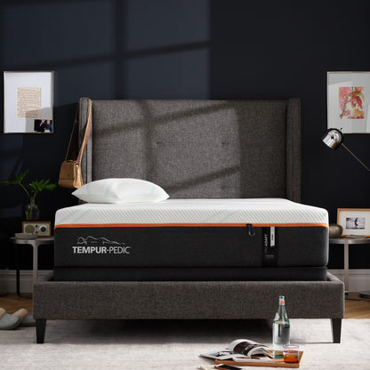 Tempur-Pedic ProAdapt Firm mattress in a stylish bedroom with dark walls and a high-back upholstered bed frame, designed to deliver firm support and spinal alignment for back and stomach sleepers.
