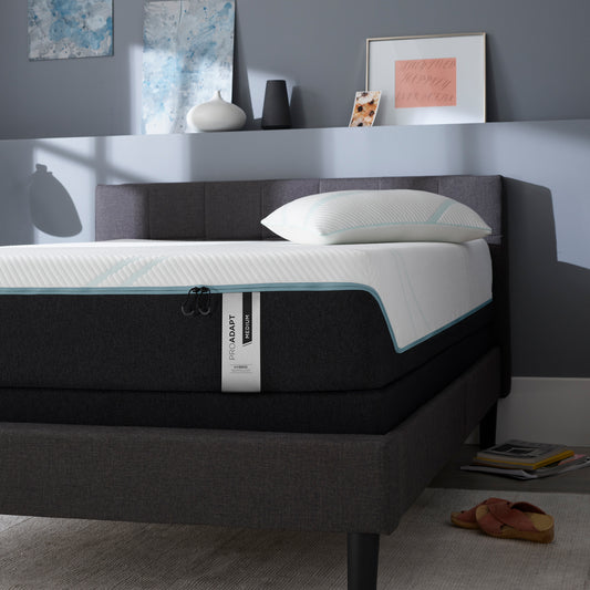 Tempur-Pedic ProAdapt Medium Hybrid mattress in a contemporary bedroom with a charcoal upholstered bed frame, highlighting the luxurious design and supportive comfort ideal for back and side sleepers.