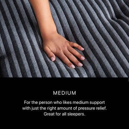 Hand pressing Beautyrest Black Series One Medium mattress surface – medium comfort feel with balanced support and pressure relief.