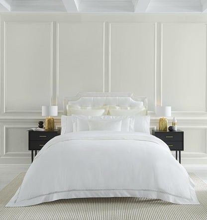 SFERRA bedding on a made bed in a bedroom