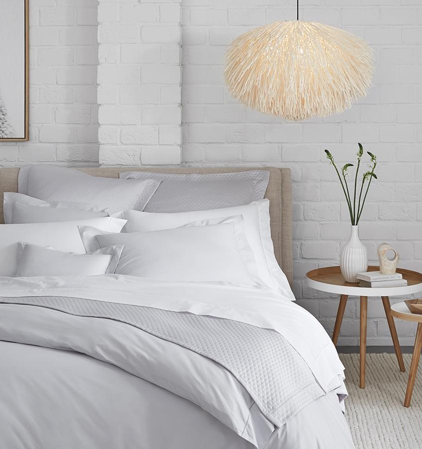 SFERRA bedding on a made bed in a bedroom